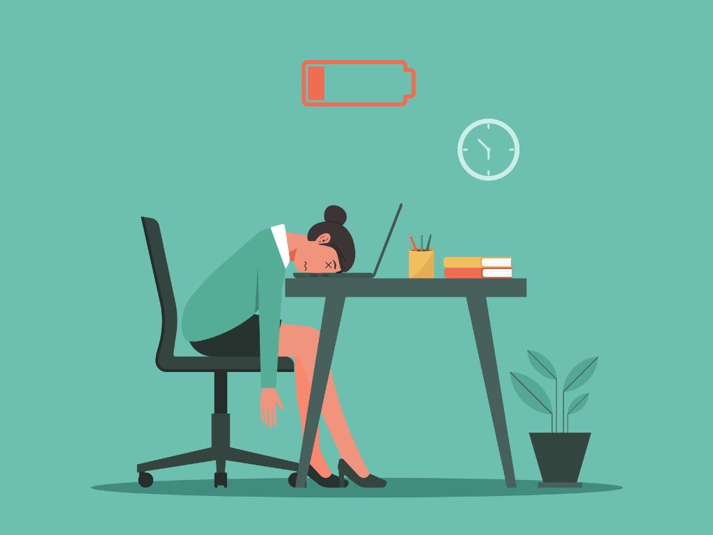 How to cope with burnout: woman with head on desk, battery empty sign